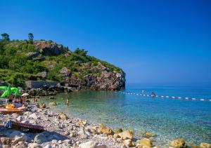 a beach with a group of people in the water at Rijeka Rezevici Apartment in Reževići