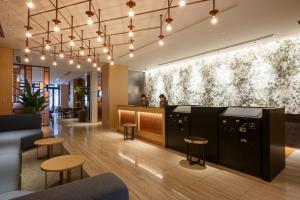 a lobby with a bar with stools and lights at Hotel Forza Osaka Kitahama in Osaka