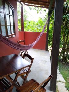 a hammock and chairs on a porch of a house at Chales do Antonio in São Pedro da Serra