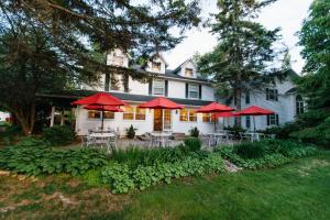 a house with tables and chairs and red umbrellas at Eagle Harbor Inn in Ephraim