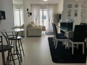 sala de estar con mesa y sillas y comedor en Apartamento Maravilhoso em Florianópolis na Praia dos Ingleses com piscina, en Florianópolis