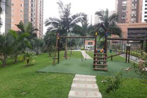 a playground in a park with a swing at Hermoso y acogedor apartamento en Belén Rodeo Alto in Medellín