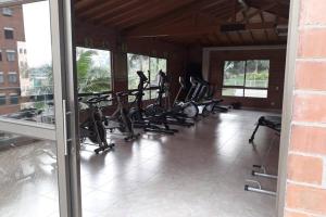 a row of exercise bikes in a gym with windows at Hermoso y acogedor apartamento en Belén Rodeo Alto in Medellín
