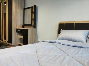 a bedroom with a large white bed and a mirror at Popular Condo เมืองทองธานี in Pak Kret