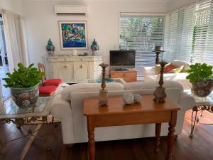 sala de estar con sofá blanco y mesa en Casa Palma, en Mission Beach