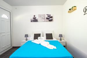 a bedroom with a blue bed with towels on it at Le paradis caché de Phedre in Sainte-Luce