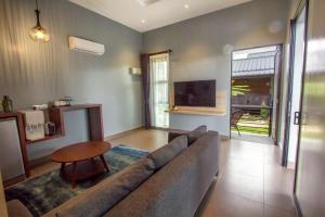 a living room with a couch and a table at VILLA PADDY in Kampung Padang Masirat
