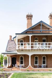 a large brick house with chairs on the porch at Byng Street Boutique Hotel in Orange