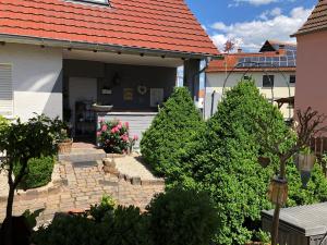 a house with a row of trees in the yard at Ferien- und Monteurswohnung Heilbrunnen in Wörth am Rhein