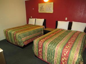 Habitación de hotel con 2 camas y pared roja en Calico Motel, en Anaheim