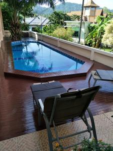 einen Pool auf einem Balkon mit einem Stuhl daneben in der Unterkunft Thalassa in Nai Harn Beach
