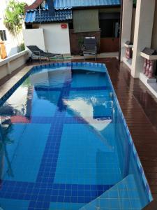 a swimming pool with blue tiles on the floor at Thalassa in Nai Harn Beach