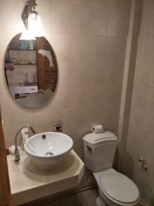 ein Badezimmer mit Waschbecken, Toilette und Spiegel in der Unterkunft Thalassa in Nai Harn Beach