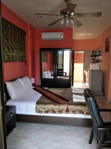 a bedroom with red walls and a bed and a chair at Thalassa in Nai Harn Beach