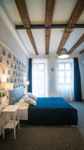 a bedroom with a blue bed and a table at Central Hotel in Lviv