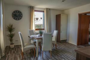 a dining room with a table and white chairs at Ferienapartment Christine in Simmerath