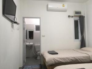 Zimmer mit 2 Betten und einem Bad mit einem Spiegel in der Unterkunft Phutawan Pundao in Mae Taeng