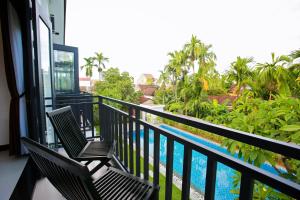 un balcón con 2 sillas y una piscina en Hoi An Hideaway Villa en Hoi An