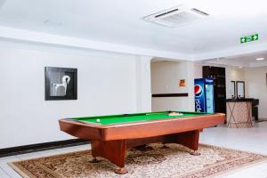 una mesa de billar en una sala de estar con accesorios en Mayfair Hotel en Dar es Salaam
