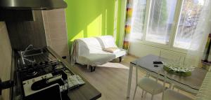 a kitchen with a stove and a table and a chair at B&B CAV Rondinella in Chiavenna