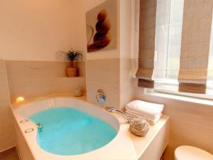 a bathroom with a bath tub with a window at Hotel Kriemhild am Hirschgarten in Munich