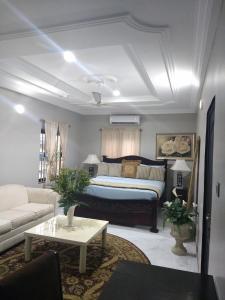 uma sala de estar com uma cama e um sofá em The Winford Boutique Hotel Achimota em Accra