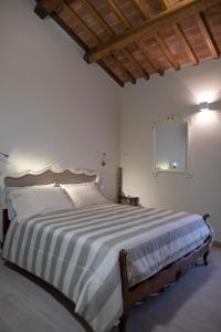 a bedroom with a large bed with a striped blanket at Il Palazzetto in Bagnoregio