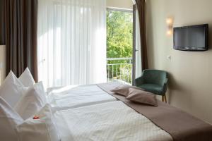 Un dormitorio con una gran cama blanca y una ventana en Stadthaushotel Hamburg - Inklusionshotel, en Hamburgo