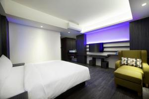 una camera da letto con un letto, una scrivania e una sedia di Seven Fukun Hotel a Jiaoxi