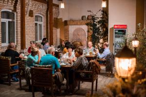 فندق مليكة بخارى في بوكسورو: مجموعة من الناس يجلسون على الطاولات في المطعم
