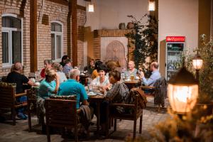 a group of people sitting at tables in a restaurant at Hotel Malika Bukhara in Bukhara