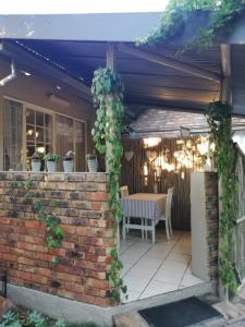 a patio with a table and a bunch of vines at Garsfontein Bed and Breakfast in Pretoria