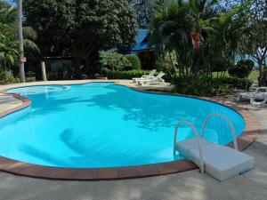 a large blue swimming pool with a bench around it at Rung Arun Resort in Ban Tai