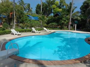 une grande piscine avec deux chaises et une table dans l'établissement Rung Arun Resort, à Baan Tai