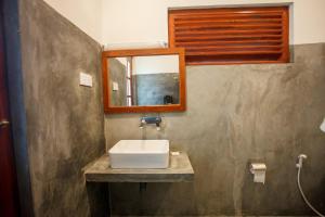een badkamer met een wastafel en een spiegel bij Ella Rawana Den Hotel in Ella