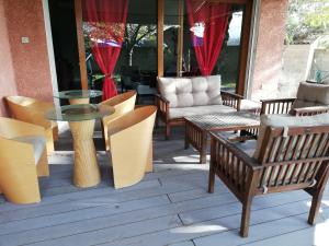 a patio with chairs and a glass table and chairs at Maison D architecte chez Huguette in Villalier