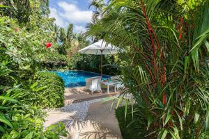 a swimming pool with a table and an umbrella at Lokal Phuket "Former K-Hotel" - SHA Extra Plus in Patong Beach