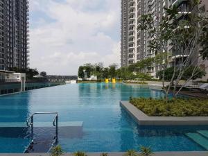 a large swimming pool in the middle of two tall buildings at Southville Stay @ Savanna Executive Suite in Bangi