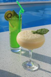 a drink in a martini glass with a green garnishment at Del Mare семейный корпус in Kapchagay