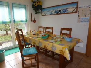 a dining room table with chairs and a yellow table cloth at B&B Les Acacias in Le Châble