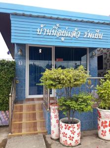 a building with two potted trees in front of it at Muean Fhan Resort Aranyaprathet in Aranyaprathet