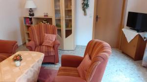 a living room with two chairs and a table at Preisbewusste Ferienwohnung für 2 Personen u. Kleinkind in Utarp