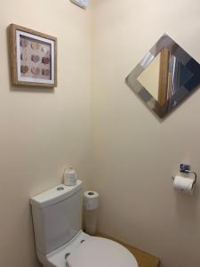 a white bathroom with a toilet and a mirror at Lakeview Guest House in Stranraer