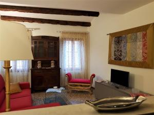 ein Wohnzimmer mit einem roten Sofa und einem TV in der Unterkunft Cà Melidissa in Venedig