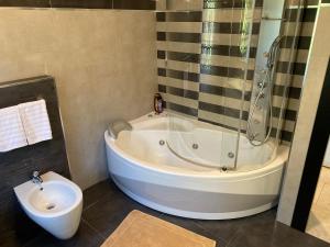 a bathroom with a tub and a shower and a toilet at apartment Lac Brusimpiano in Brusimpiano +58 photos