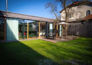 a backyard with a patio with an umbrella and a table at Zeitraumferien in Bernau am Chiemsee