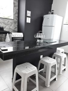 una cocina con una encimera con taburetes enfrente en Reduto Praiano - Thaiz Hospedagem, en Cabo Frío