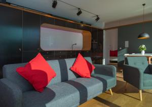 a living room with a blue couch with red pillows at Zeitraumferien in Bernau am Chiemsee