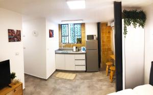 a kitchen with a sink and a refrigerator at Locals TLV - Herzl Street in Tel Aviv