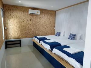 a bedroom with two beds with blue and white pillows at Lamoon Boutique Hotel in Suphan Buri